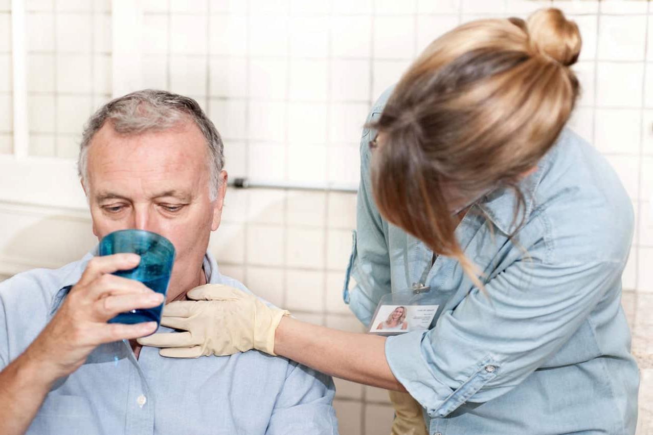 nurse giving man water